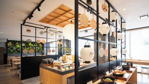 A restaurant interior with a central wooden counter, seating area, and decorative lanterns. - Super Hotel Kyoto Shijyo Kawaramachi (Kyoto)