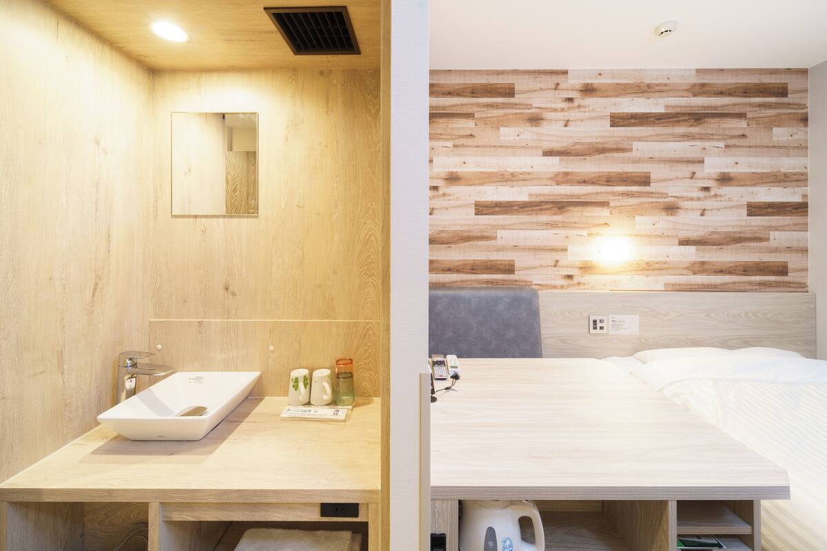 Une salle de bain moderne avec un meuble-lavabo en bois, un évier et un miroir.