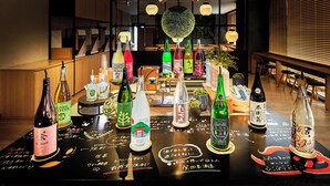 A bar area with various bottles of beverages and a black table with handwritten notes. - Super Hotel Kyoto Shijyo Kawaramachi (Kyoto)