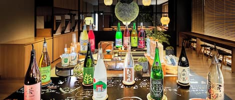 Una zona de bar con diversas botellas de bebidas y una mesa negra con notas escritas a mano.