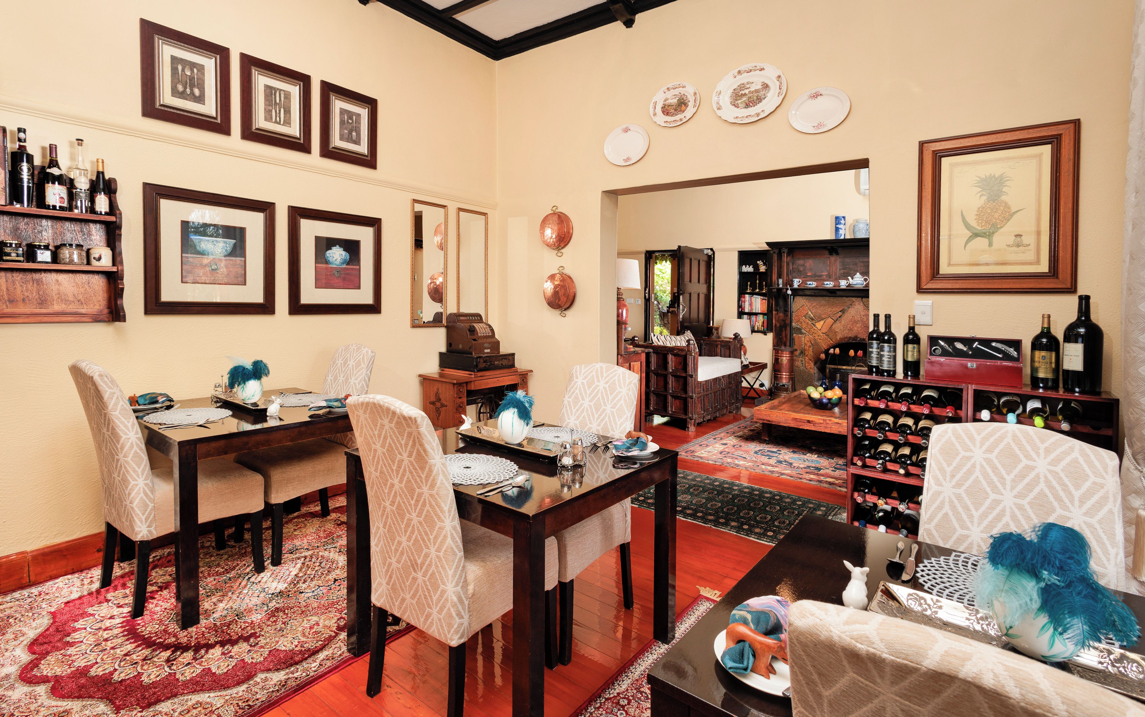 A dining area with a wooden table, chairs, and a red patterned rug.