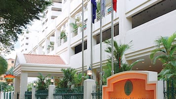 A hotel entrance with a sign reading "Norfolk Mansion" and flags.