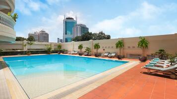 Una piscina al aire libre, tumbonas