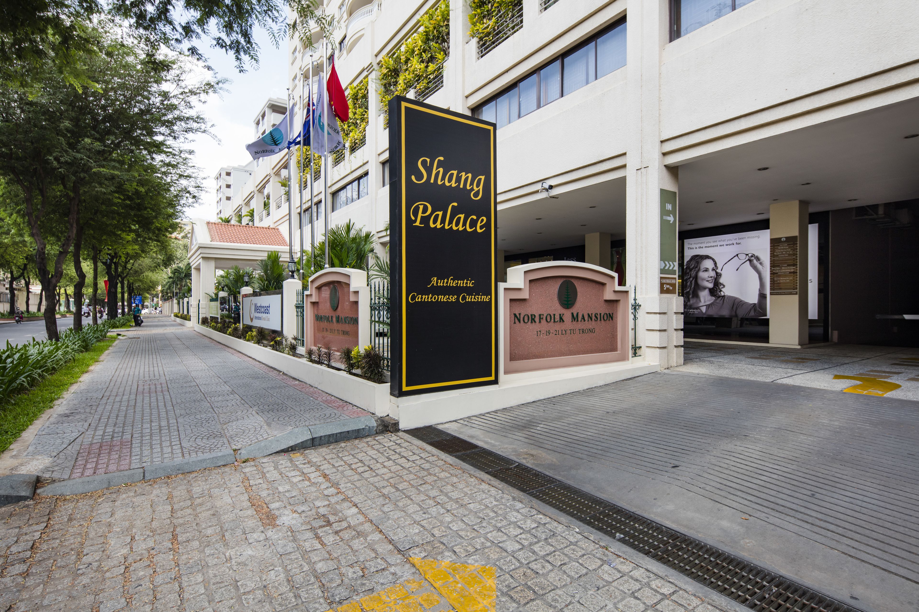 L'ingresso di un hotel con insegna Shang Palace, caratterizzato da uno stile architettonico asiatico tradizionale, un portico coperto e un percorso ben definito che conduce all'entrata.