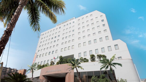 A multi-story hotel with a modern design, featuring a prominent entrance and a clear sky in the background. - Nogami President Hotel (Iizuka)