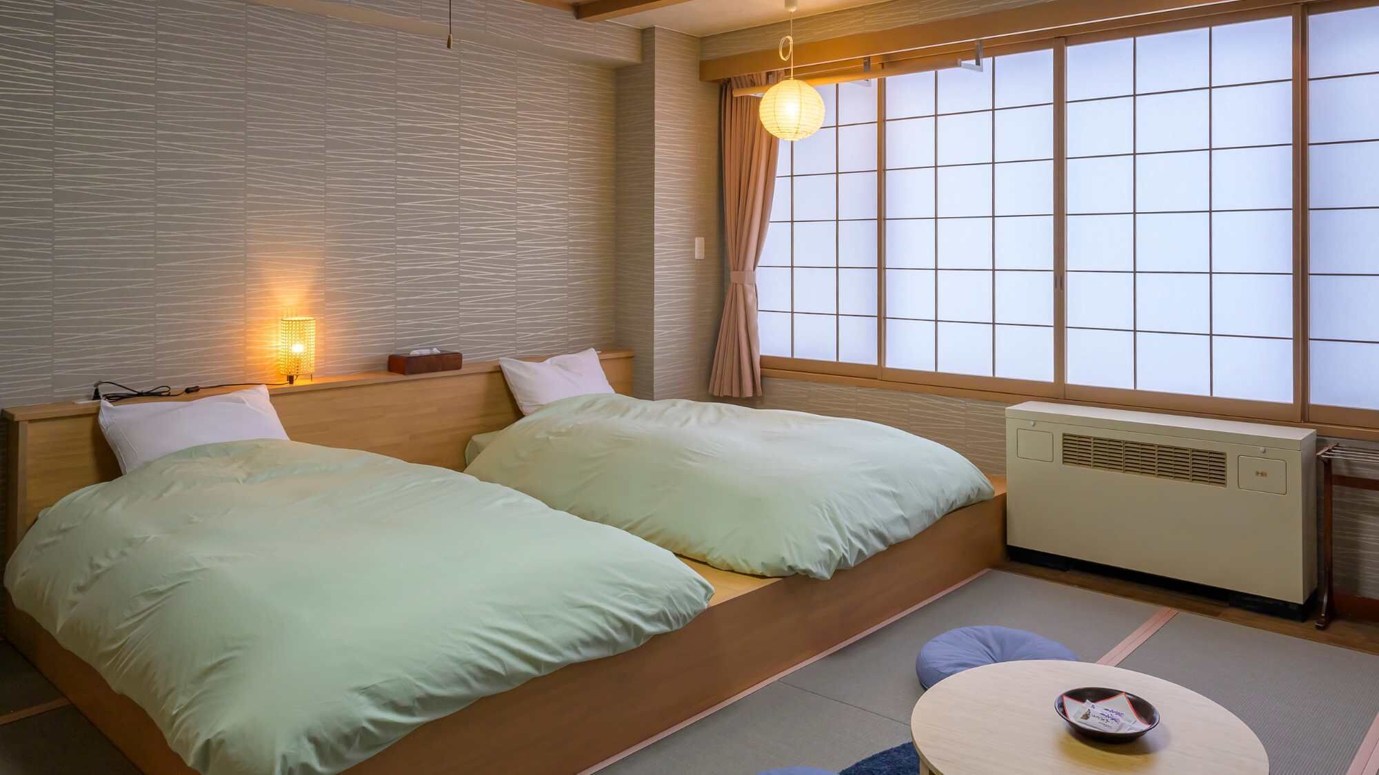 A room with a bed, a table, a heater, and a window with a view.