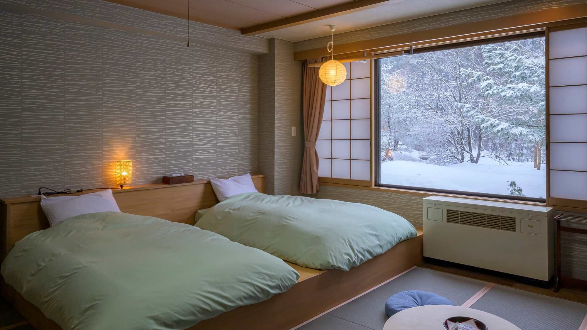 A room with two beds, a window with a view of a snowy landscape, a wall with a textured pattern, and a hanging light fixture.