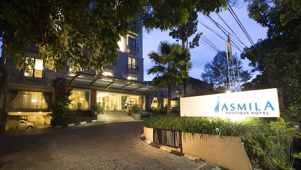 A hotel entrance with a sign reading "ASMILA BOUTIQUE HOTEL".