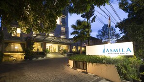 Entrada de un hotel con un letrero que dice "ASMILA BOUTIQUE HOTEL".