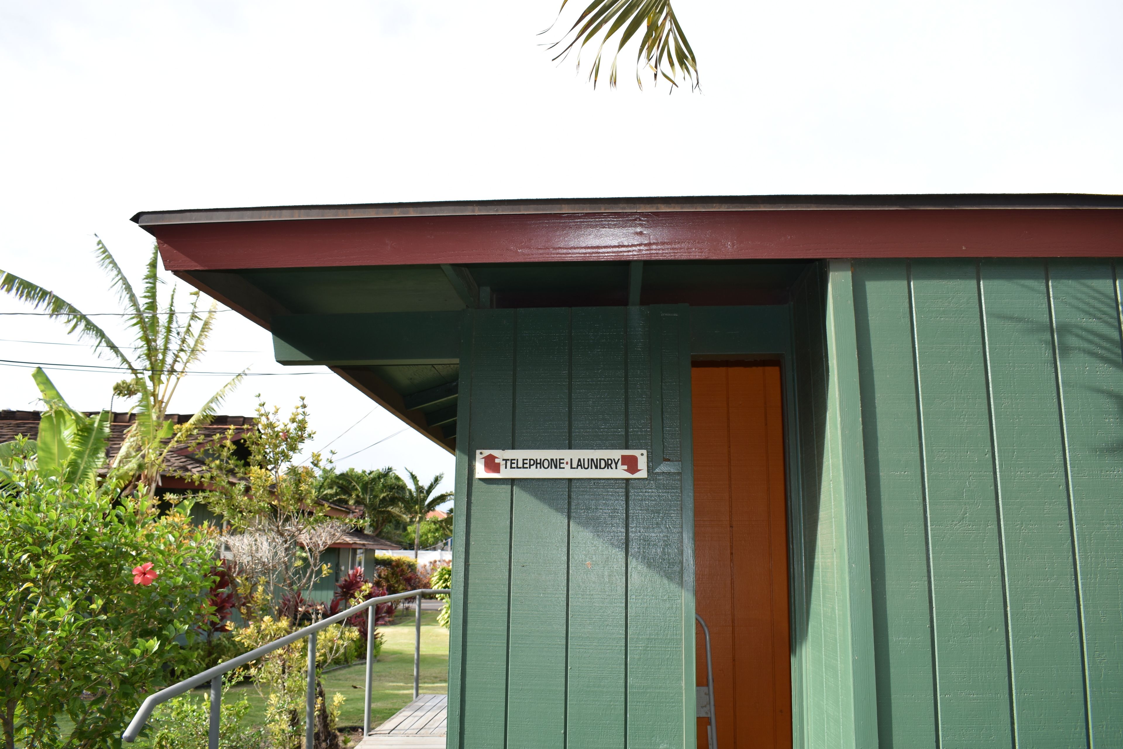 A small building with a sign reading "Telephone Laundry" and a door.