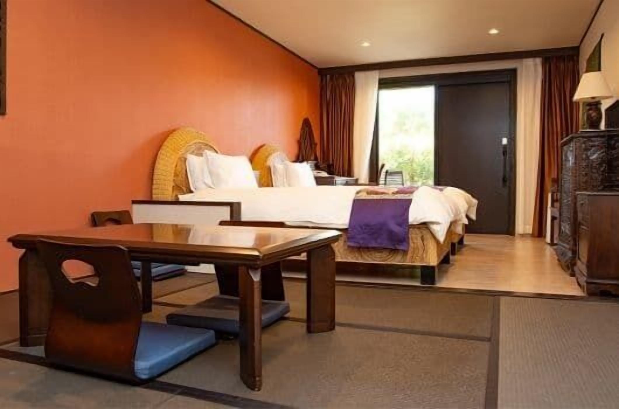 Una habitación de hotel con cama, escritorio y una silla.