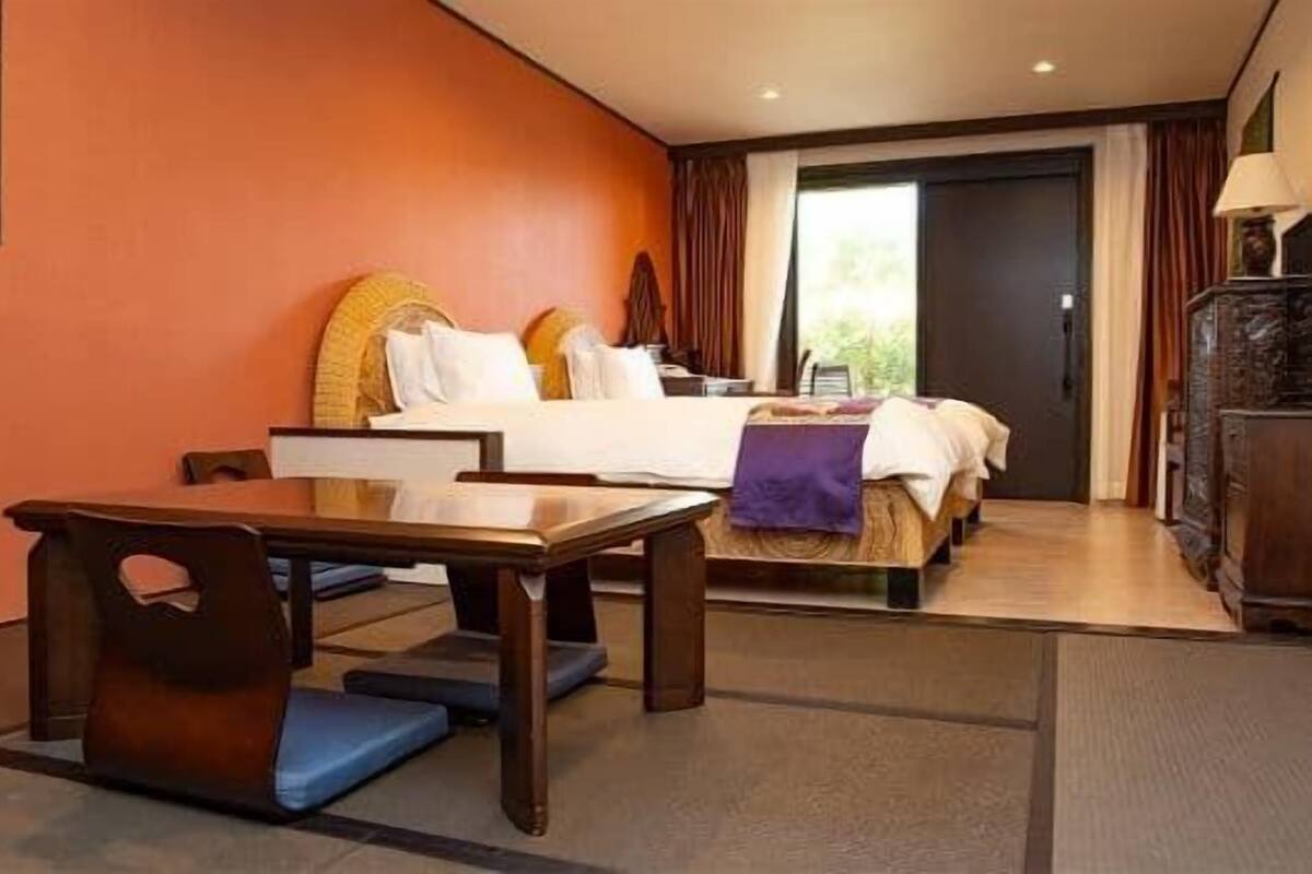 A hotel room with a bed, a desk, and a chair.