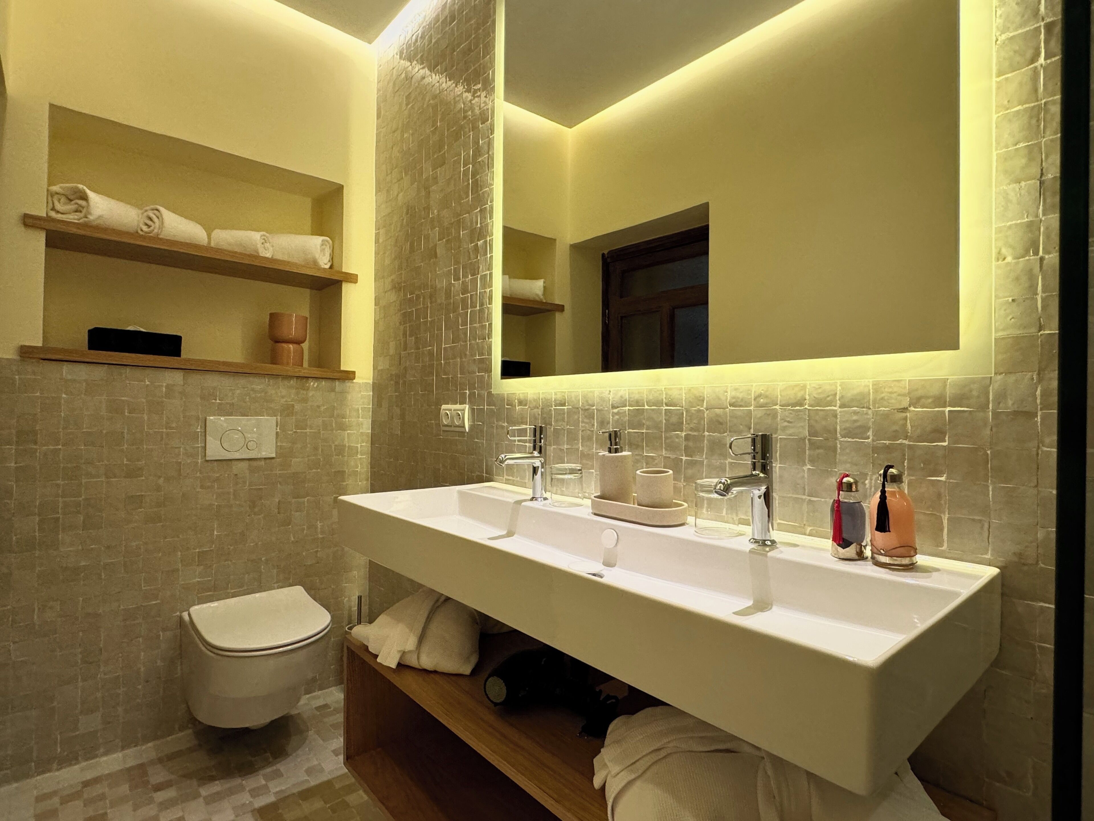 A bathroom with a large sink, mirror, and towel rack.