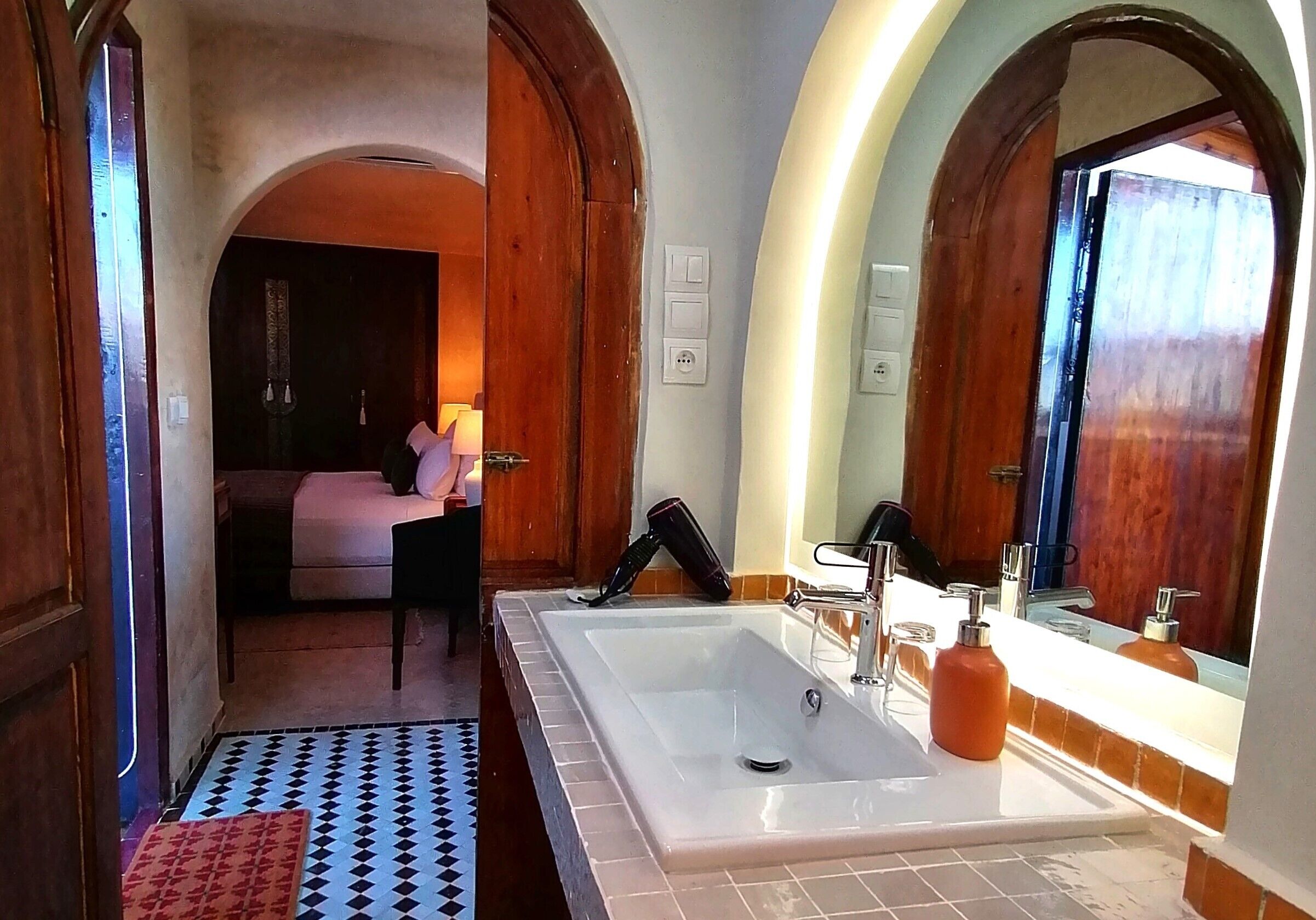 A bathroom with a large bathtub, a sink with a mirror, and a shower area.