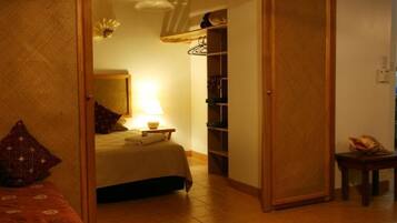 A bedroom with a bed, bedside table, lamp, and a wardrobe.