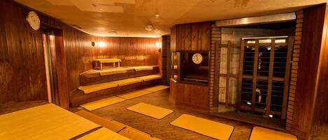 Una sala de sauna con paredes, bancos y un reloj de madera.