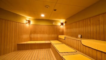 Una sala de sauna con paredes y bancos de madera.