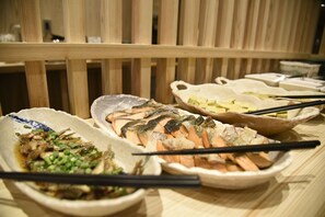A variety of dishes including salmon and other seafood, served on a wooden table with chopsticks. - Miyazaki Daiichi Hotel (Miyazaki)