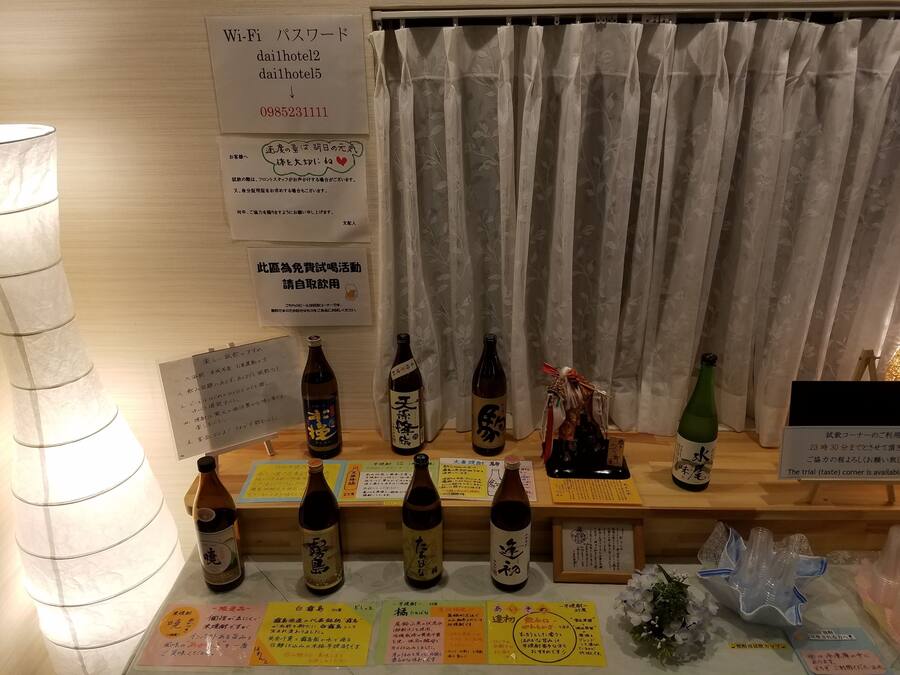 Zona de recepción de un hotel, con varios letreros y botellas de bebidas a la vista.