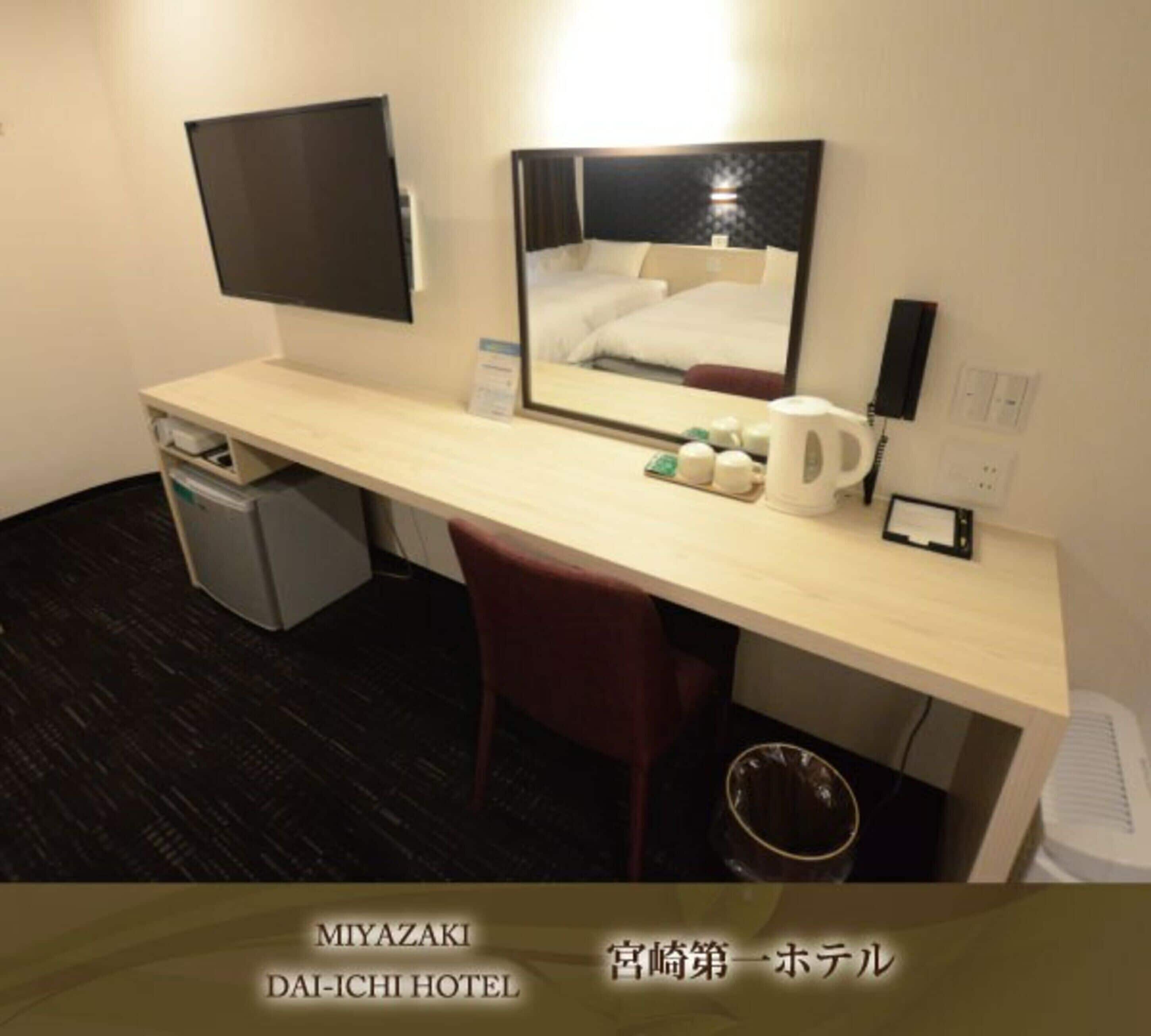 Une chambre d’hôtel équipée d’un bureau, d’une chaise, d’une télévision et d’un miroir.