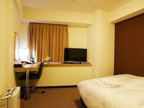 A hotel room with a bed, a desk with a computer and a television, a window with curtains, and a wall-mounted mirror. - Century Art (Fukuoka)