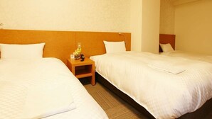 A hotel room with two single beds, a wooden nightstand with a lamp, and a small table with a vase of flowers. - Century Art (Fukuoka)