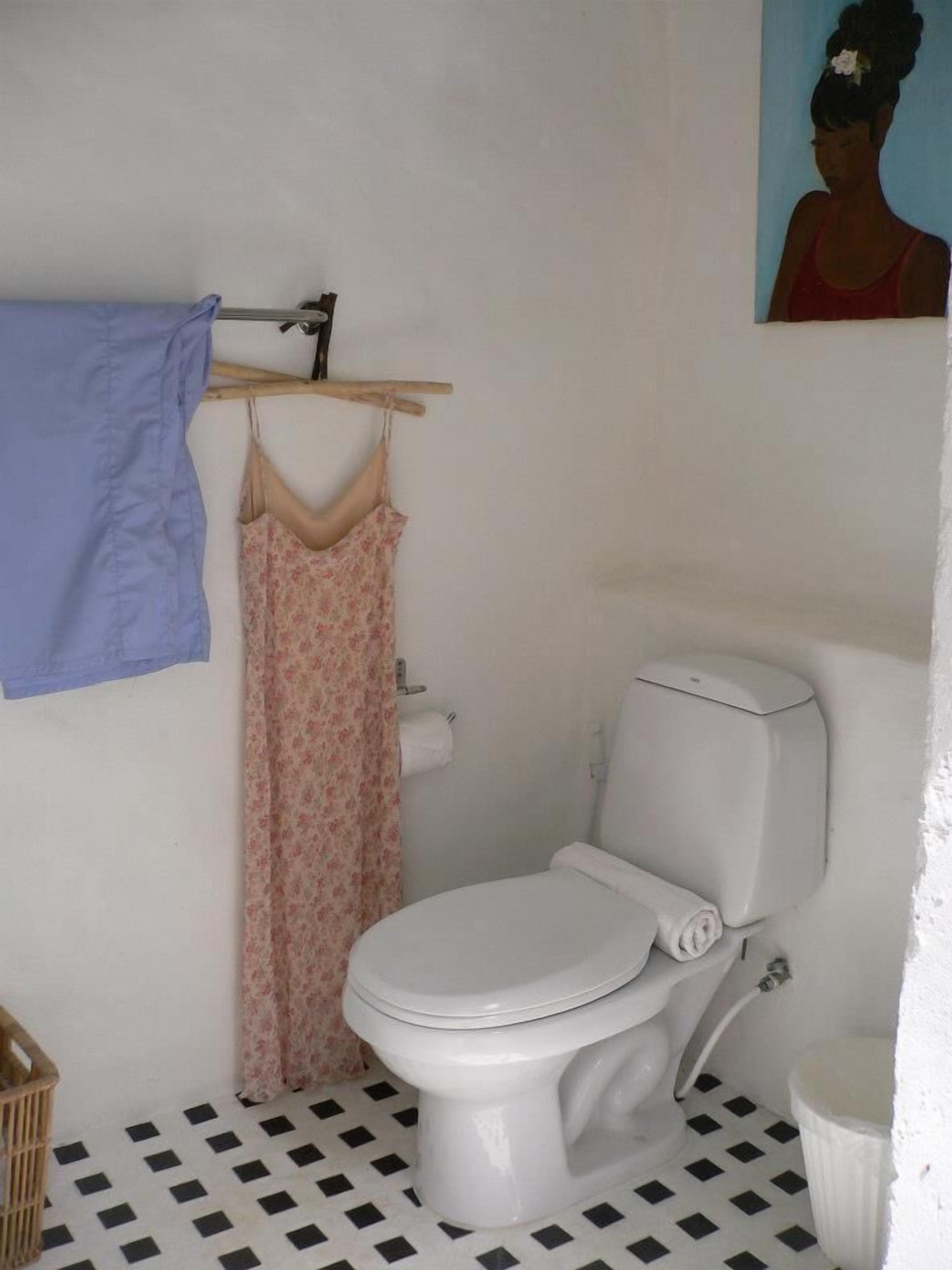 A small bathroom with a toilet, a sink, and a shower area.