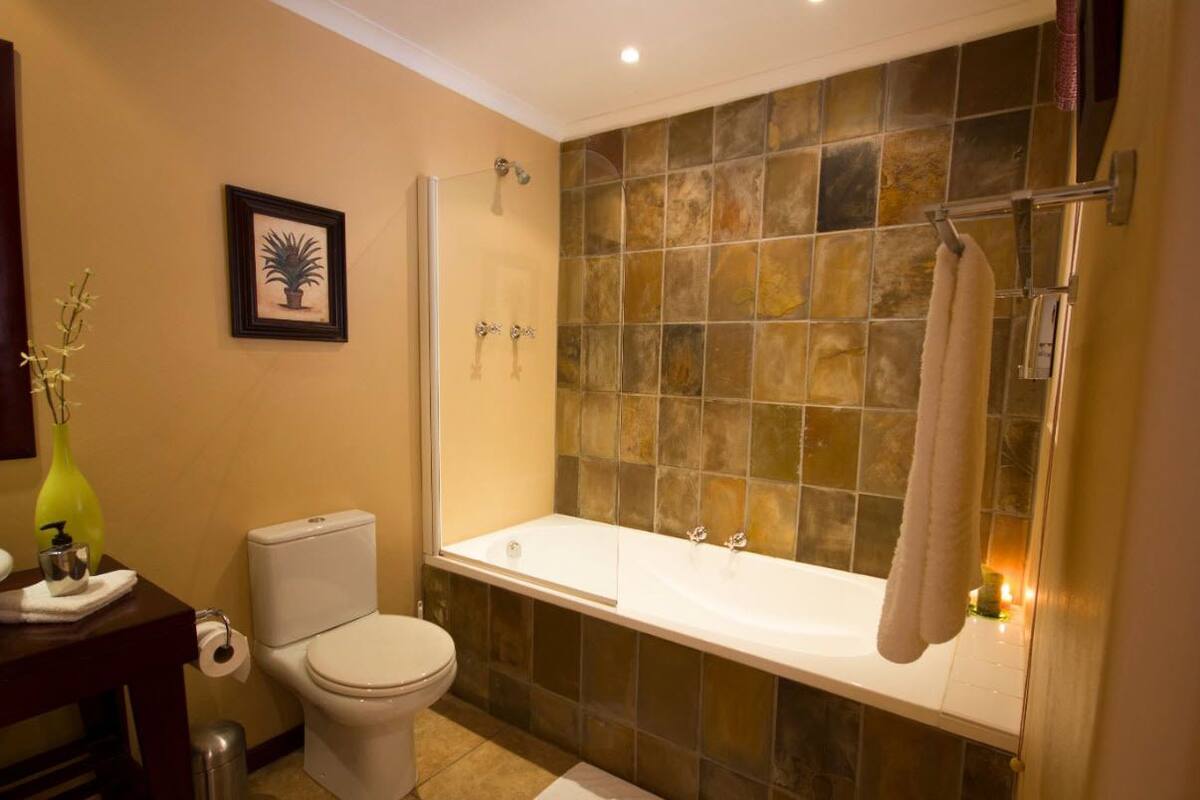 Une salle de bain comprenant des toilettes, un lavabo, une baignoire et une douche.