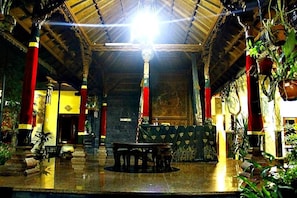 An indoor space with a high ceiling, columns, and a central table. - Nakula Guest House (Kuta)