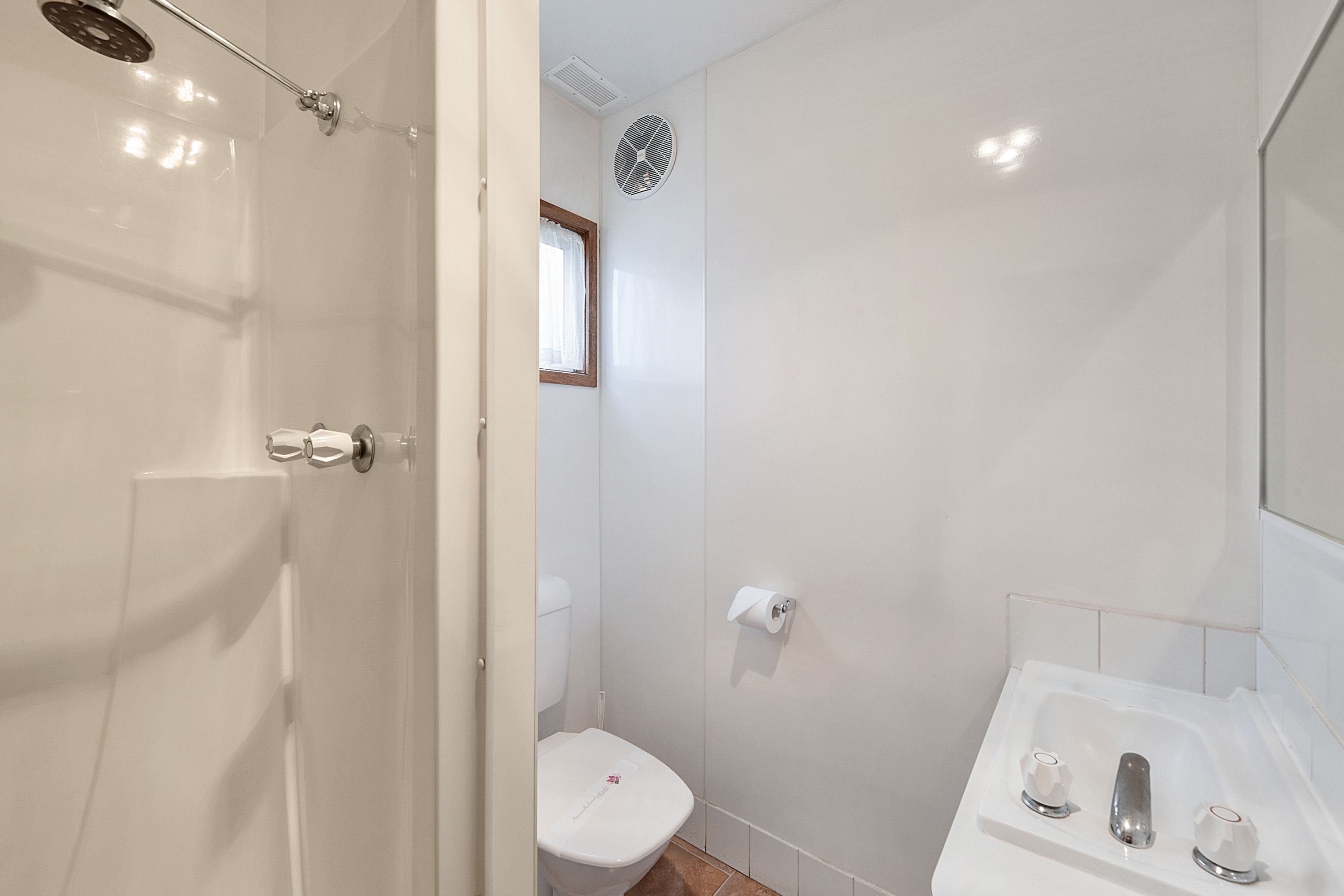 A bathroom with a shower, toilet, and sink.