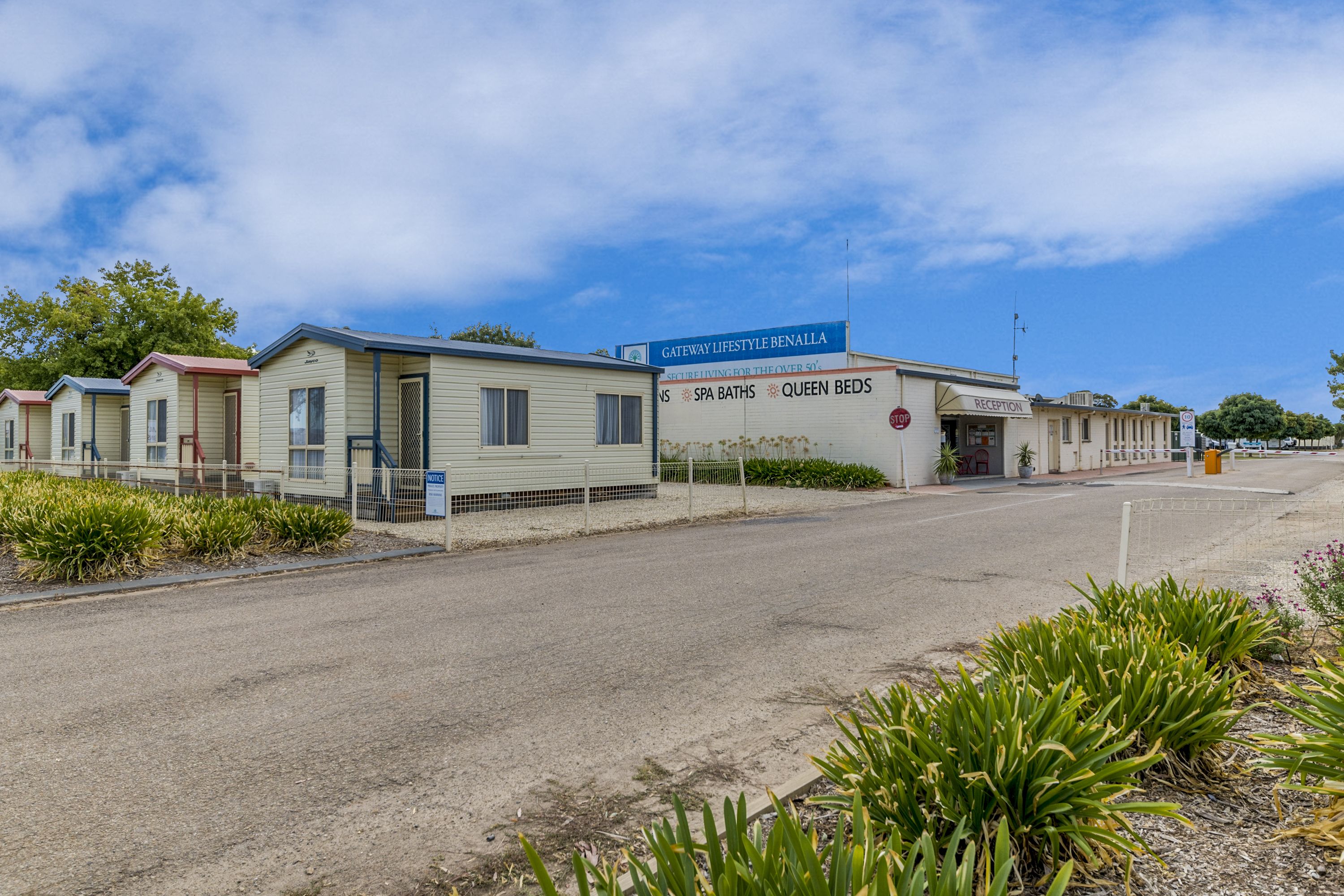 A row of mobile homes with a sign advertising spa baths and queen beds.