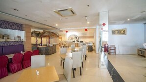 A spacious restaurant with multiple seating areas, including a bar and a dining section with tables and chairs.