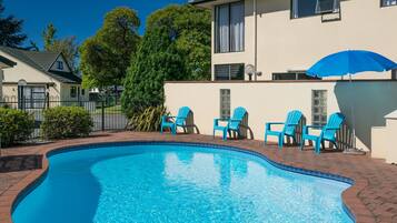 Relax by the pool surrounded by a brick patio and four comfortable chairs.