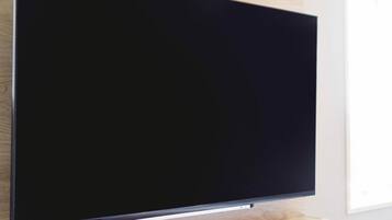 A flat-screen TV mounted on a wall with a wooden panel design.