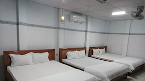 A hotel room with four single beds, each with a wooden headboard and white bedding. - Hai Hien Guesthouse Phu Quoc (Phu Quoc)