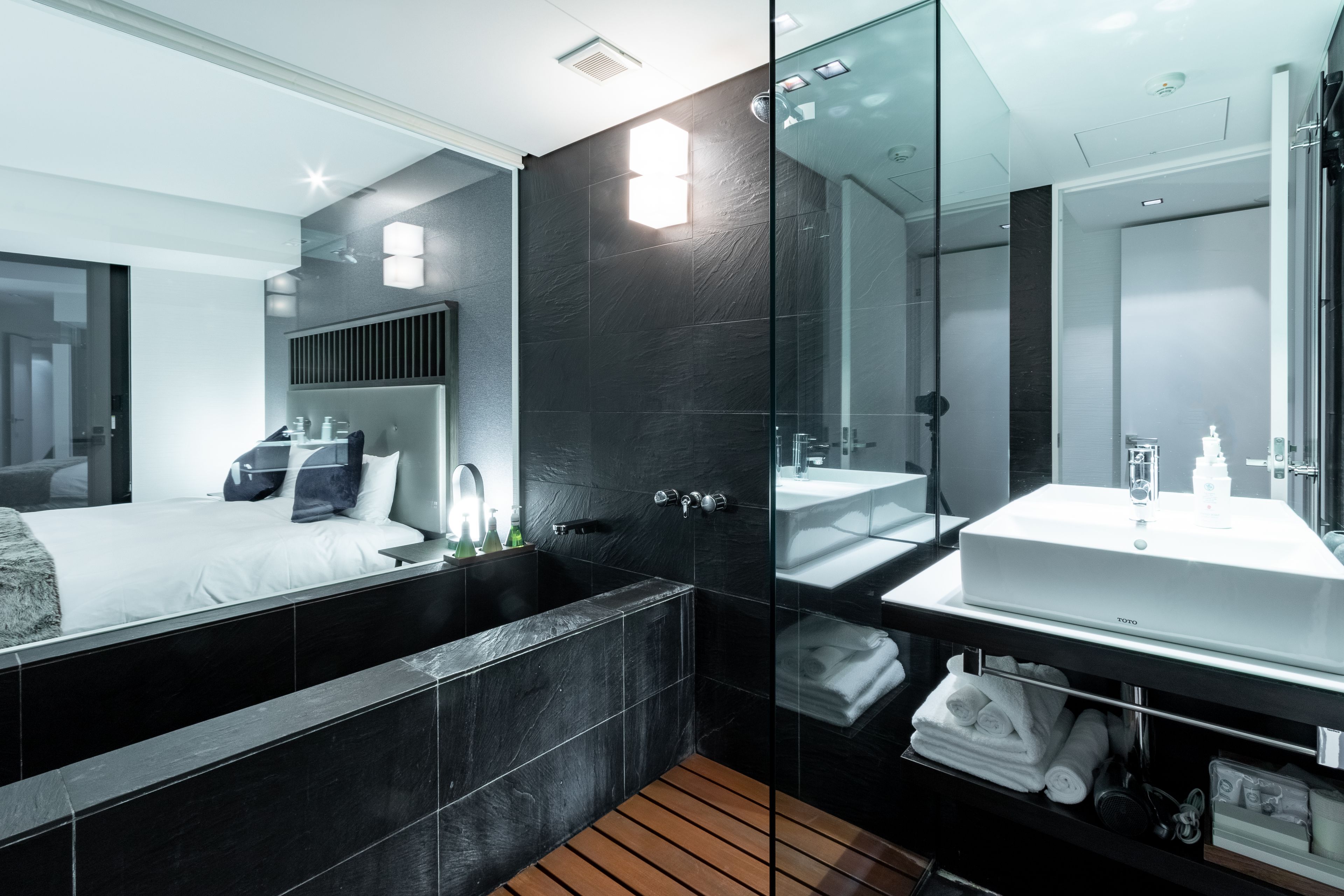 A modern bathroom with a large mirror, a bathtub, and a vanity with a sink.