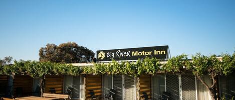 A motor inn with outdoor seating and a covered patio area.
