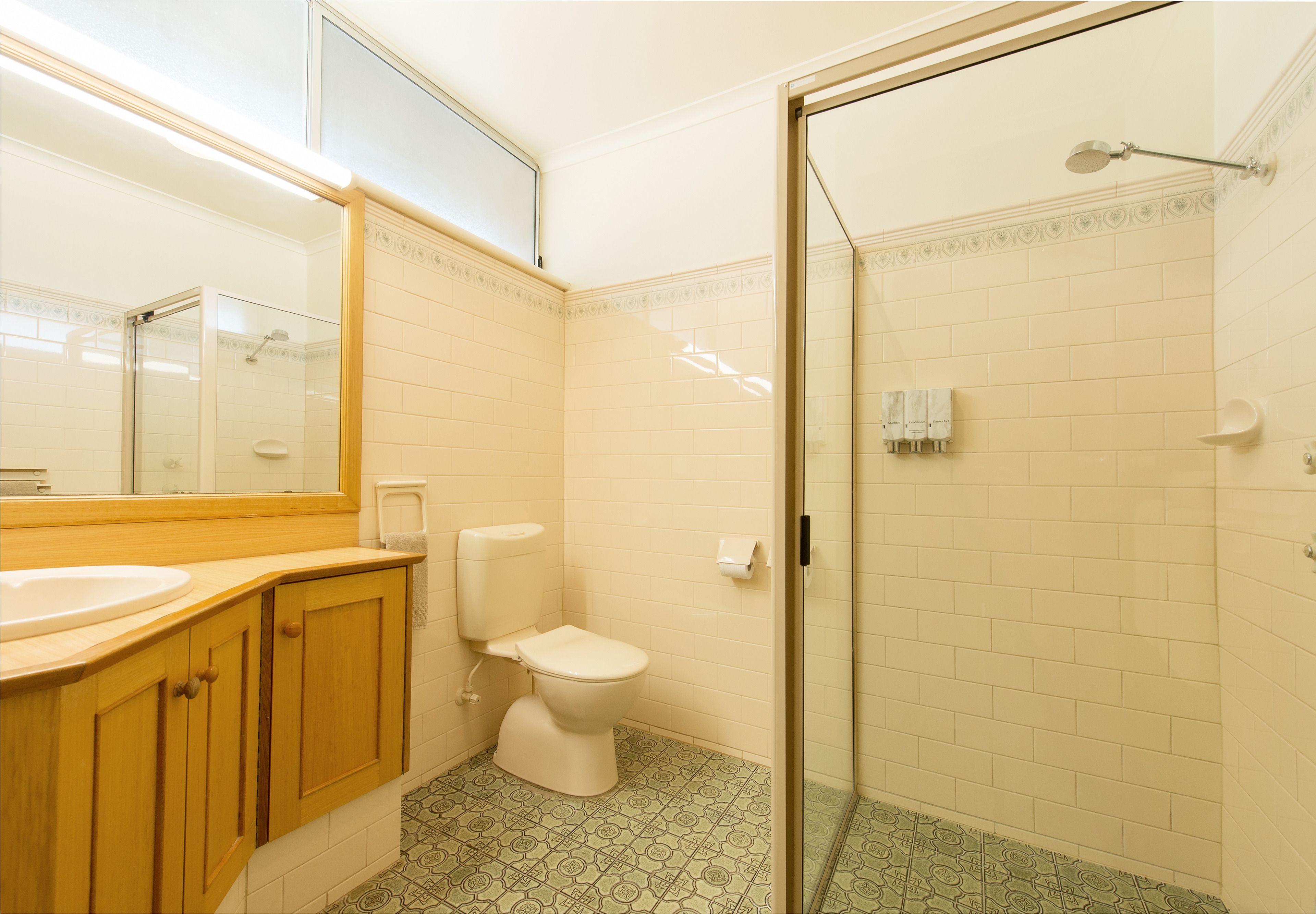 Une salle de bain comprenant des toilettes, un lavabo et un espace douche.