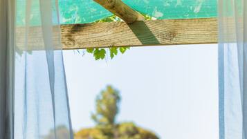 Relax in a serene garden setting with a shaded pergola and comfortable seating area.