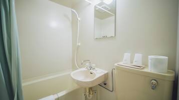 Un baño con lavamanos, espejo, inodoro y ducha.