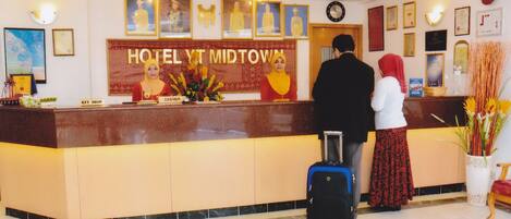 Una recepción de hotel con un cartel que dice "HOTEL YT MIDTOWN".