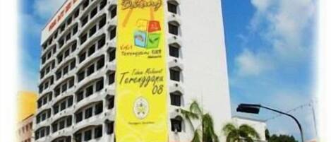 Un hotel de varios pisos con un llamativo letrero amarillo que anuncia una oferta especial.