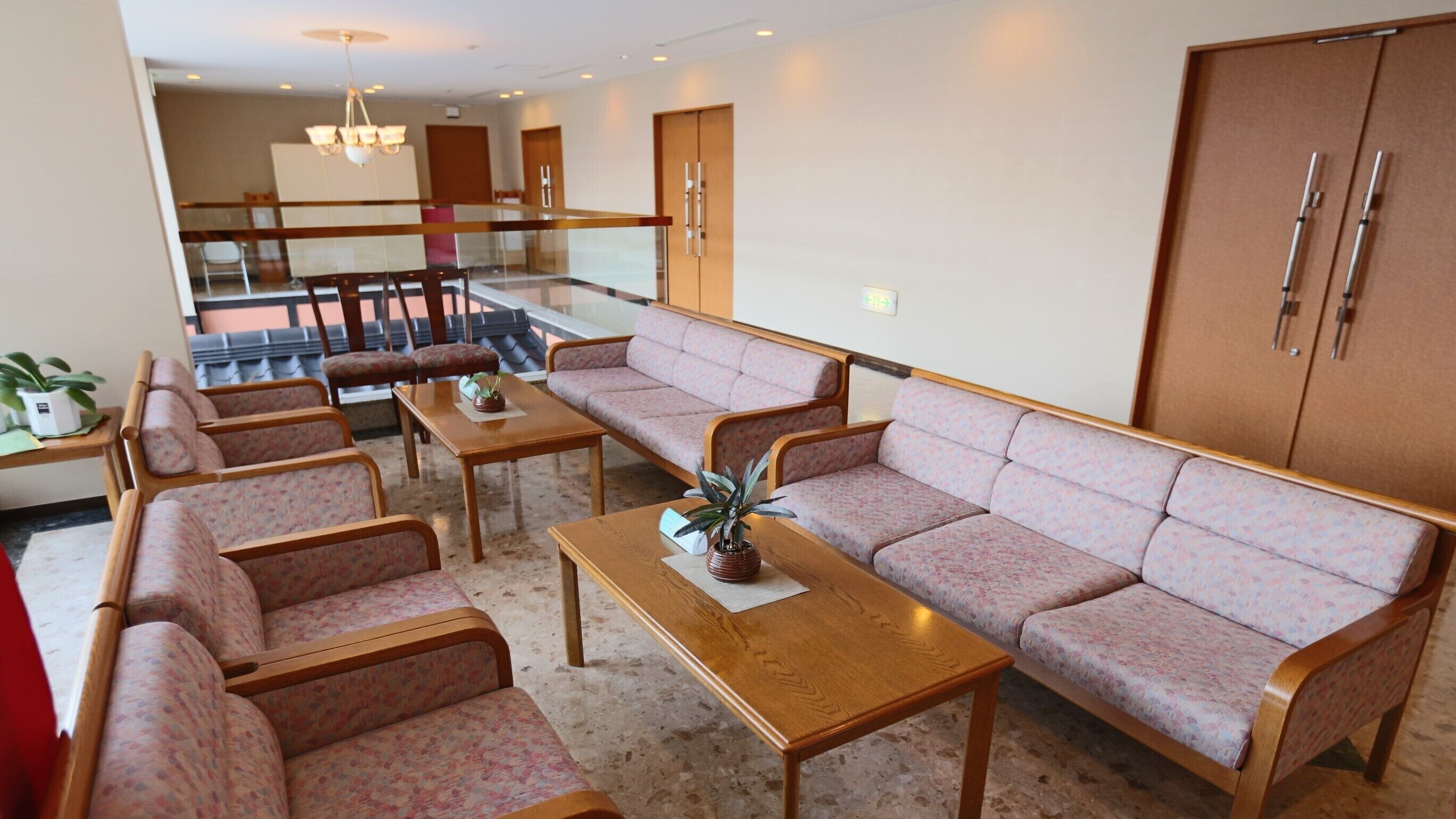 A spacious living room with a sofa set, a coffee table, and a dining area with chairs.
