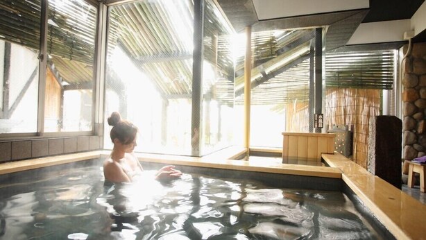 Baño de aguas termales con vista a una estructura tradicional de bambú.