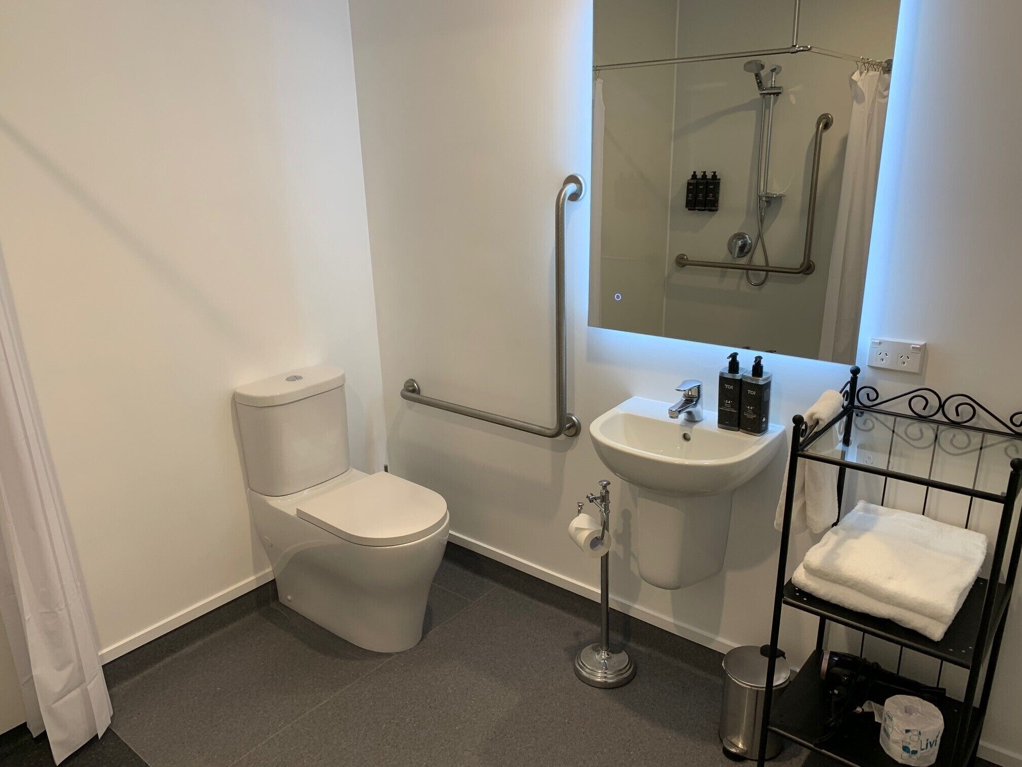 A modern bathroom with a toilet, sink, and shower.