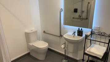 A modern bathroom with a toilet, sink, and shower.