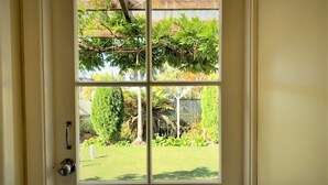 A door with a view of a backyard garden through a window. - Tongariro Crossing Lodge (National Park Village)