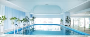 An indoor swimming pool with clear blue water, surrounded by potted plants and modern architecture. - Ha Long DC Hotel (Ha Long)