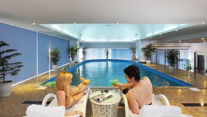 A pool area with two people seated at a table, a pool, and potted plants. - Ha Long DC Hotel (Hong Gai)