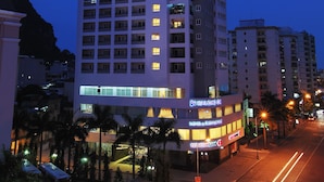 A high-rise hotel with multiple floors, illuminated windows, and a prominent sign at the top. - Ha Long DC Hotel (Hong Gai)